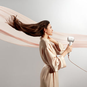 Woman styling hair with Dreame Hair Glory high-speed dryer, showcasing airflow and smooth finish.
